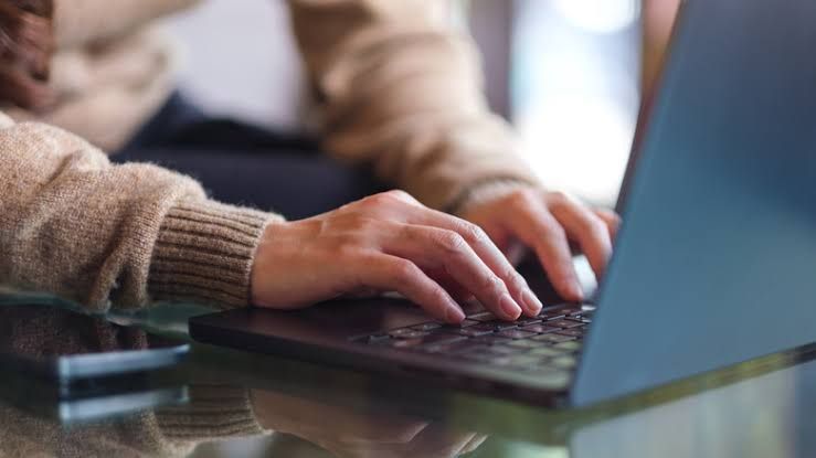 A person using a laptop with a high-speed fiber optic connection graphic overlaid.