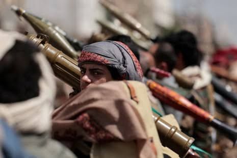 Houthi rebel fighter carrying a rifle in Yemen amid ongoing military tensions.