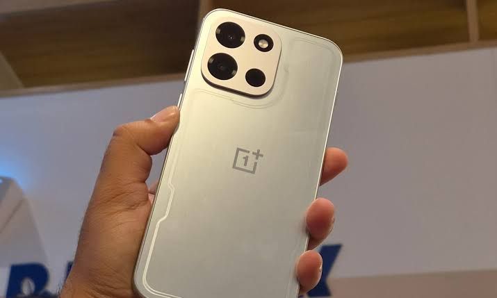 OnePlus Nord 6 held in a hand against a blurred background.