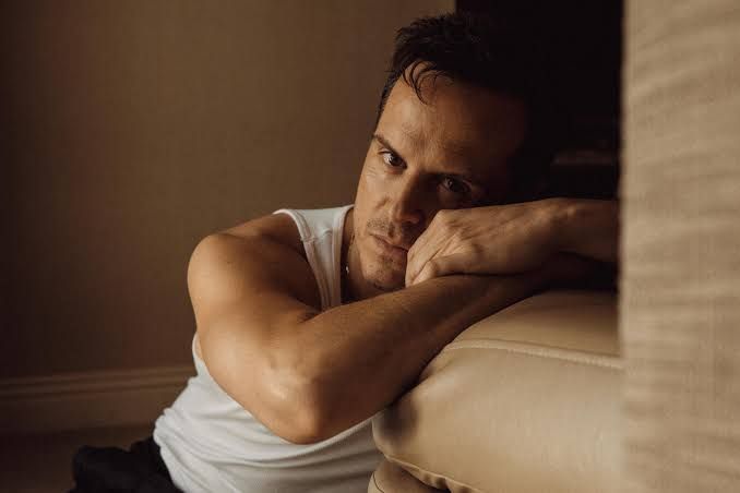 Andrew Scott sits in a restaurant booth, looking thoughtful while discussing his new film Elsinore at Telluride.