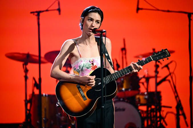 Gracie Abrams performing on stage with a red backdrop during a taping of The Tonight Show Starring Jimmy Fallon.
