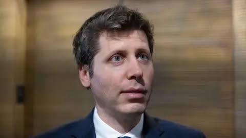 Sam Altman speaking to reporters in an office lobby regarding recent company progress.