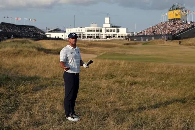 Bryson DeChambeau walking on the course during The Open Championship while appearing frustrated by a rules decision.