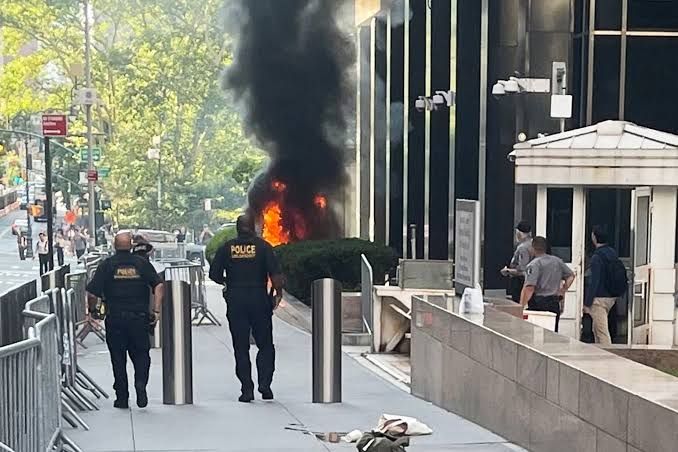 A fire burns on the sidewalk in front of 26 Federal Plaza in Lower Manhattan following an attack on the federal building.