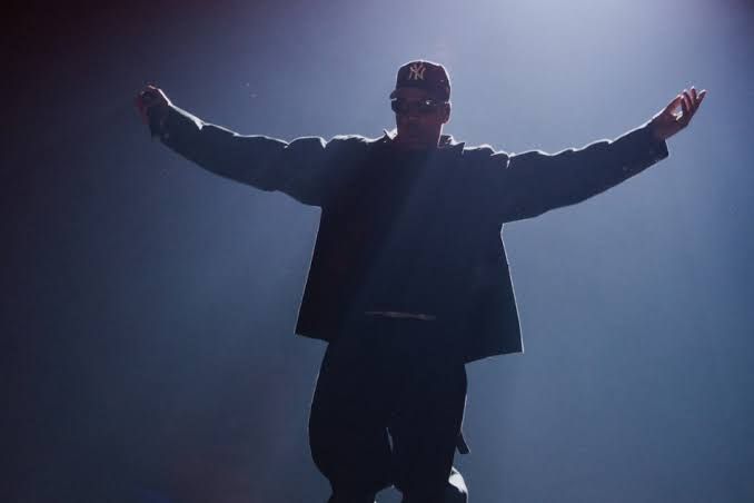 Jay-Z performs live at Tottenham Hotspur Stadium in London, wearing a Yankees cap during his 2026 concert return.
