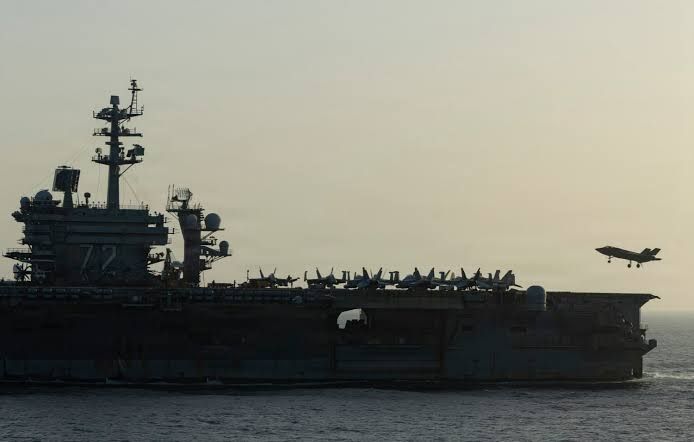 U.S. Navy destroyer patrolling the Strait of Hormuz near oil tankers.
