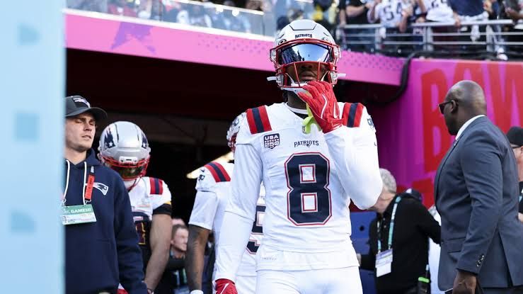 Stefon Diggs in his uniform standing on the field during an NFL game.