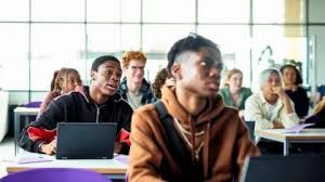 Students using laptops in a classroom, representing the focus of the University of Sussex mental health guidance.