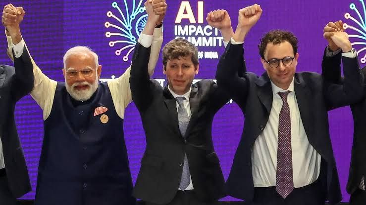 Sam Altman and Dario Amodei stand with Prime Minister Narendra Modi during a summit on artificial intelligence technology.
