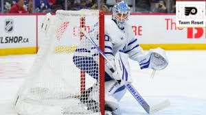 Philadelphia Flyers goalie Dan Vladar blocking a shot during a tense playoff game.