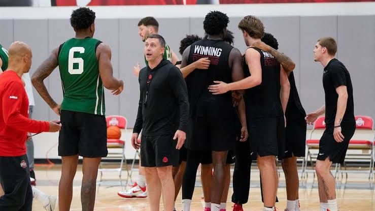 Jake Diebler instructing Ohio State basketball players during an intense practice session on the court.
