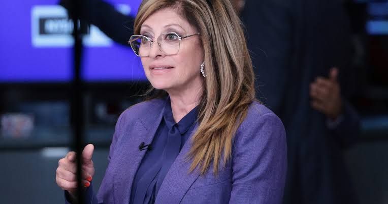 Maria Bartiromo standing in a news studio during a broadcast for Fox News.