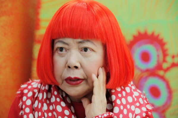 Yayoi Kusama wearing a red wig and polka dot scarf during a 2012 interview in her Tokyo studio.