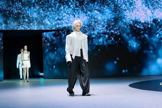 A female U1 humanoid robot with silicone skin standing on a stage during a public demonstration.