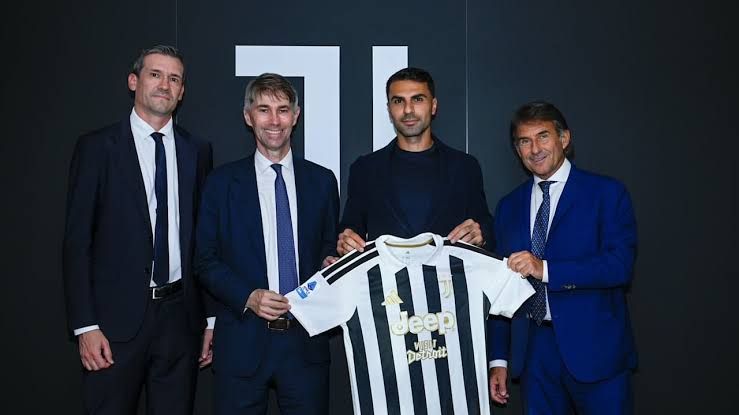 Zeki Celik standing on the pitch at Allianz Stadium wearing the official Juventus jersey.