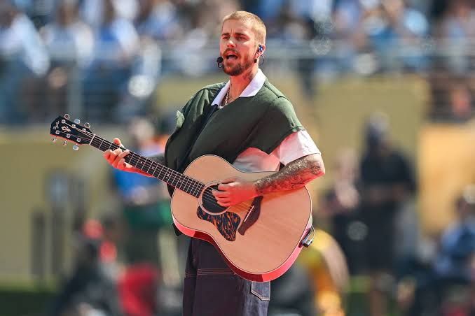 Justin Bieber performing with an acoustic guitar during the FIFA World Cup 2026 final halftime show.