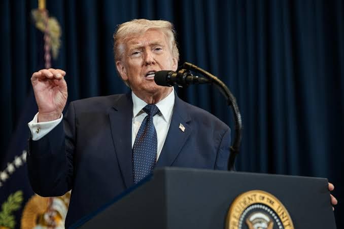 President Donald Trump speaking at a podium during a press event regarding economic policy.