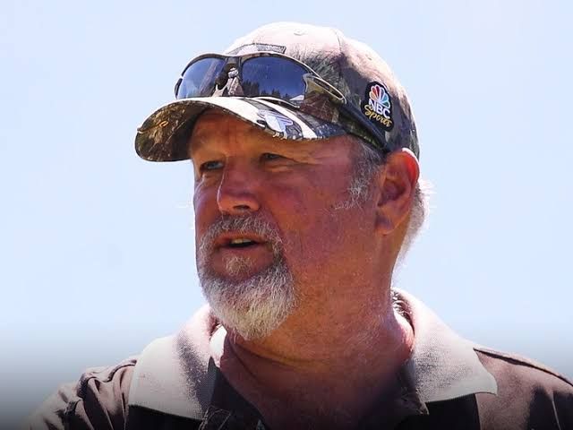 Larry the Cable Guy standing in front of a neutral backdrop while smiling at an event.