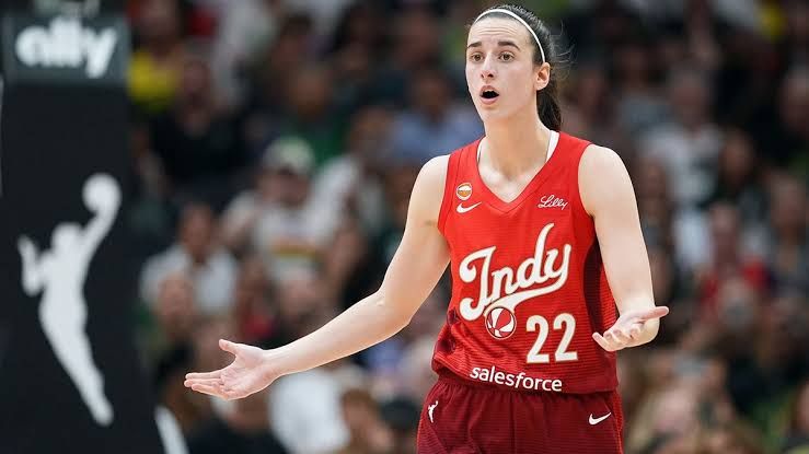 Caitlin Clark stands on the court during an Indiana Fever game with palms up while playing in the WNBA.