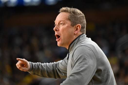 Minnesota head coach Niko Medved yelling instructions to players during a college basketball game in February 2026.