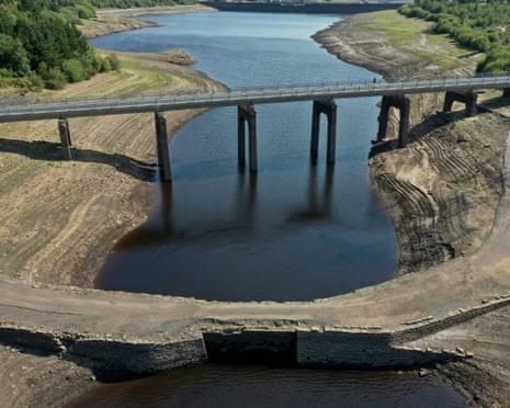 An aerial view of the Baitings Reservoir in the UK showing exposed banks due to low water levels.