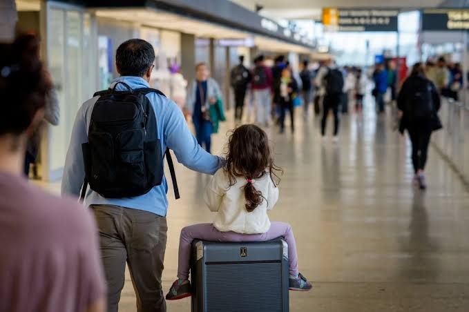 Travelers walking through Washington Dulles International Airport terminal amid global security concerns.