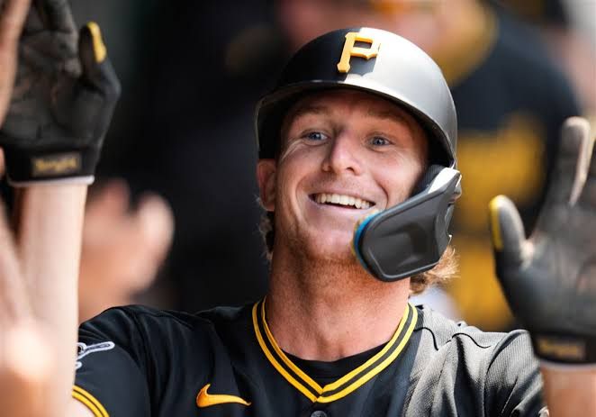 Pirates player Billy Cook celebrates in the dugout after scoring a run against the Cleveland Guardians.