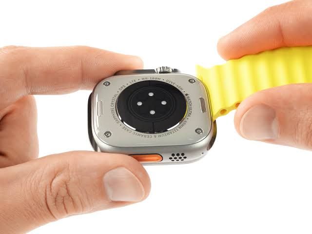 An Apple Watch Ultra rests on a surface, highlighting the design challenges of making wearable battery components accessible.