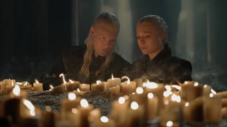 Daemon Targaryen and Rhaenyra Targaryen standing together in a stone corridor inside the Red Keep.