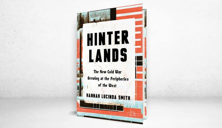 A close-up view of the book cover for Hinterlands displayed on a desk next to a copy of The Wall Street Journal.