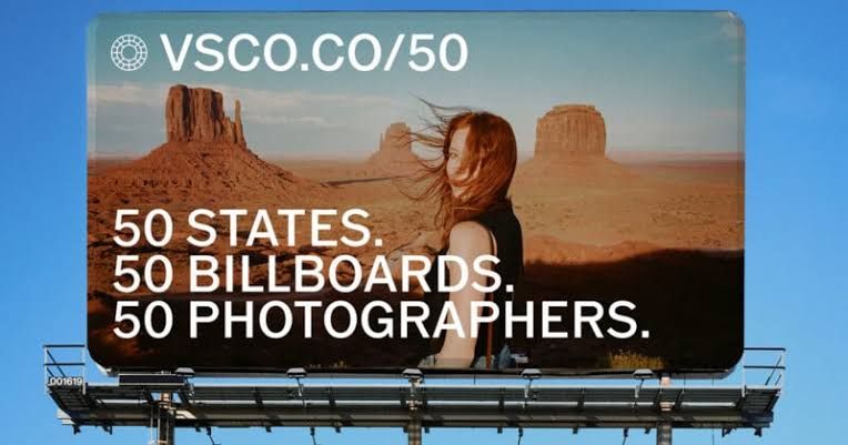 Billboard in a desert landscape displaying a VSCO open call for photographers in all 50 states.