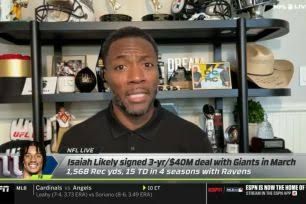 Ryan Clark speaking into a microphone while appearing on the ESPN set for an NFL Live broadcast.