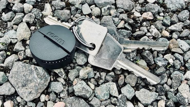 The Roam Smart Tracker device with an integrated strap shown on a dark background for product review.