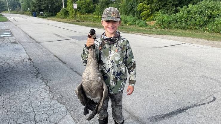 Kane Szymanski holding a Canada goose during the early hunting season in Suamico, Wisconsin.