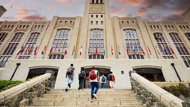 Rutgers University students walking near campus buildings during a fall morning.