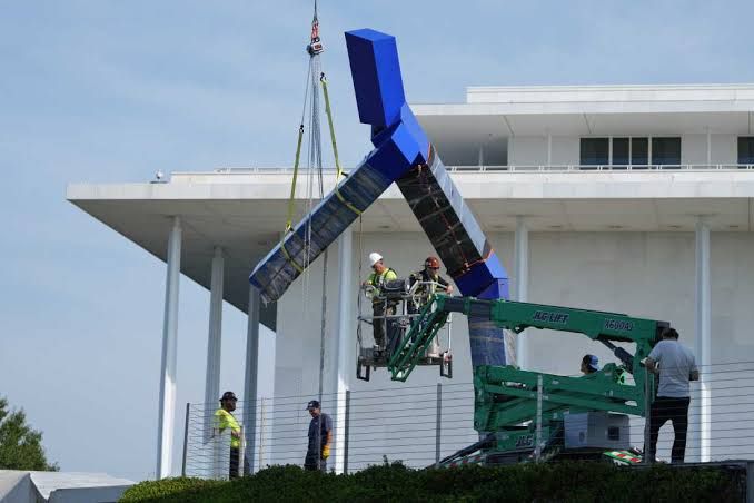 Workers dismantle the blue metal stick figure sculpture Blue by Joel Shapiro at the Kennedy Center in Washington, D.C.