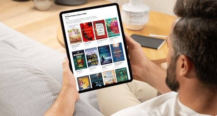A person holds a tablet displaying the Book Riot digital collection of the best mystery books of 2026.