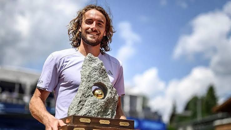 Stefanos Tsitsipas holding a trophy after winning the Swiss Open final against Raphael Collignon.