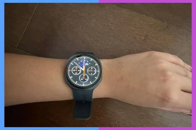 A black smartwatch with a complex digital face featuring sub-dials and a moon phase indicator worn on a wrist.