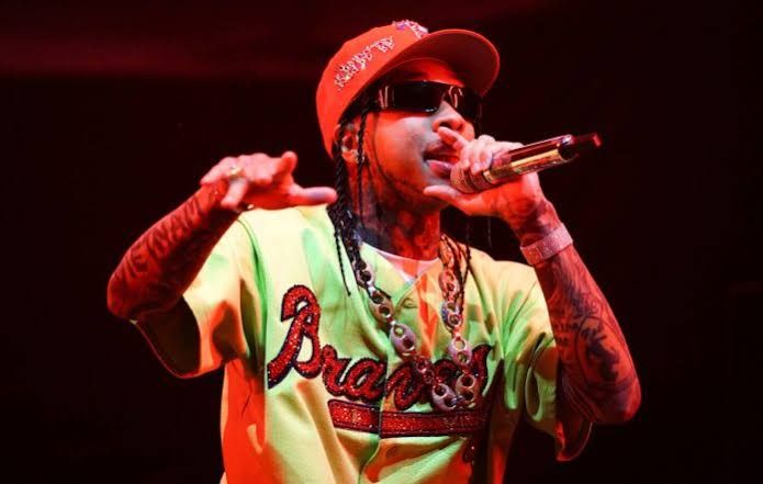 Tyga standing in a dimly lit studio environment while working on a new music project.