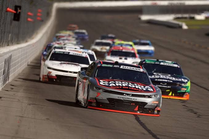 A race car speeds around a track during a NASCAR O'Reilly Auto Parts Series event at Iowa Speedway.