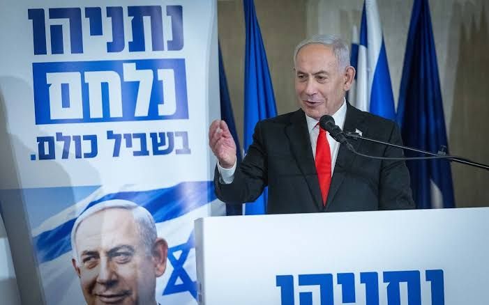 Benjamin Netanyahu standing at a podium during a press conference while addressing the media.