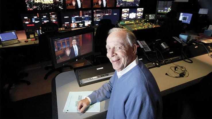 Producer Peter Lassally, wearing a suit, stands in a studio setting during his long career in late night television.
