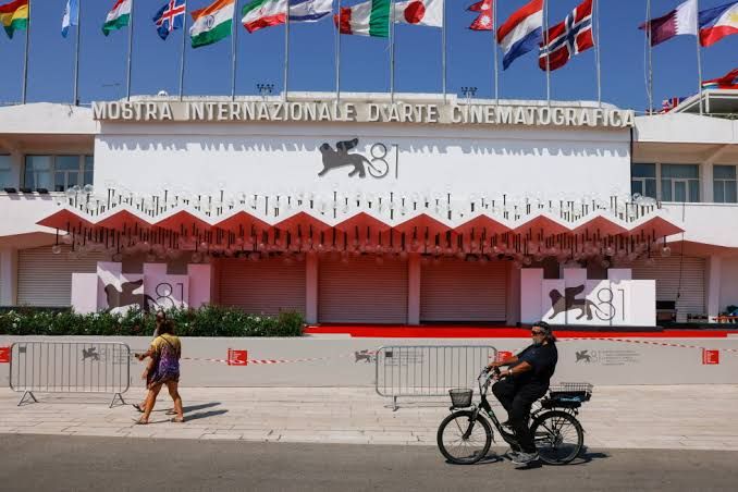 Festival goers walking on the red carpet at the Venice Film Festival venue in Italy.