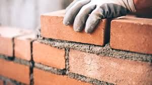 Industrial bricklayer installing bricks on a construction site in Spain.