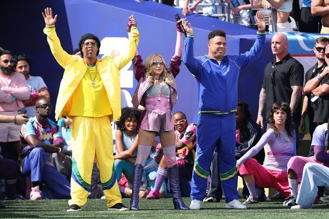 Madonna wearing Swarovski-covered gloves on the soccer pitch at MetLife Stadium during the 2026 World Cup halftime show.