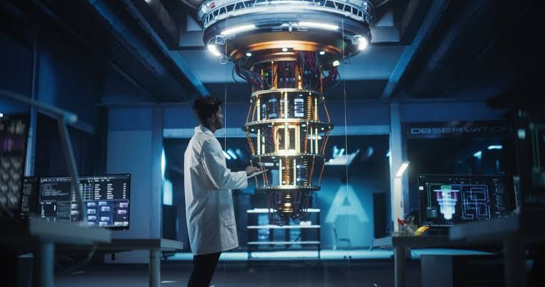 A scientist in a cleanroom lab environment adjusting laser-cooled ion hardware for quantum computing research.