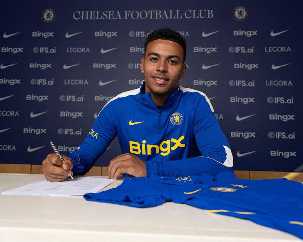 Morgan Rogers wearing a Chelsea shirt at his official signing ceremony at Stamford Bridge.