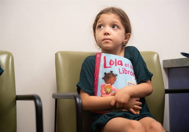 Pediatrician Michael Bertenthal shows a book to 5-year-old Elena Bezzou during a checkup in Pittsburgh.