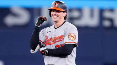 Adley Rutschman adjusting his catcher's mask during a game at Camden Yards.